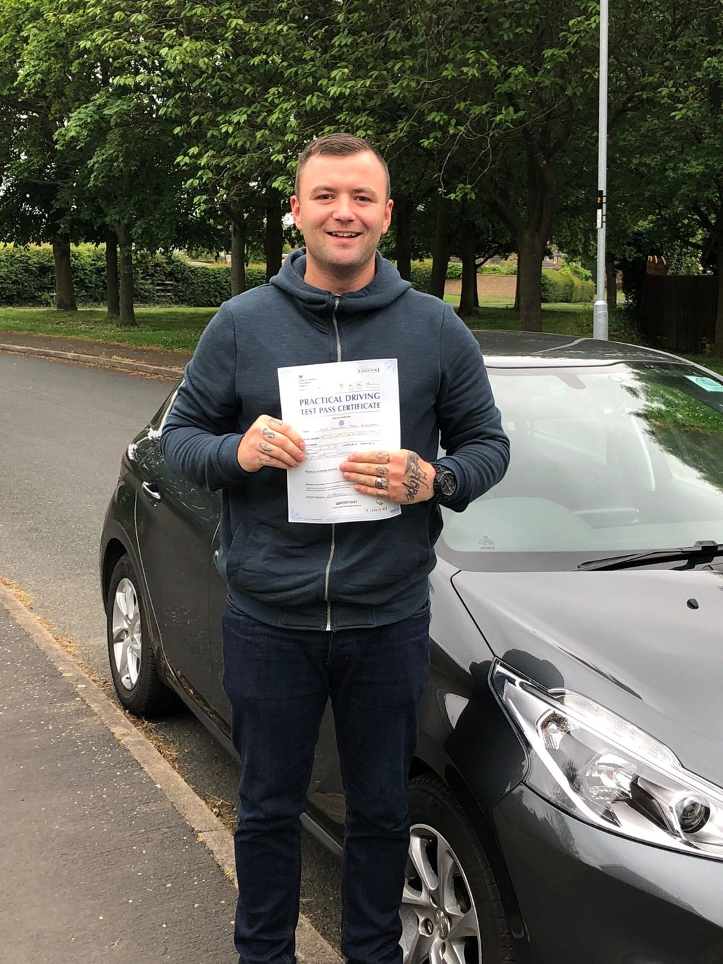 Driver holding his pass certificate after lessons with Ian's School of Motoring