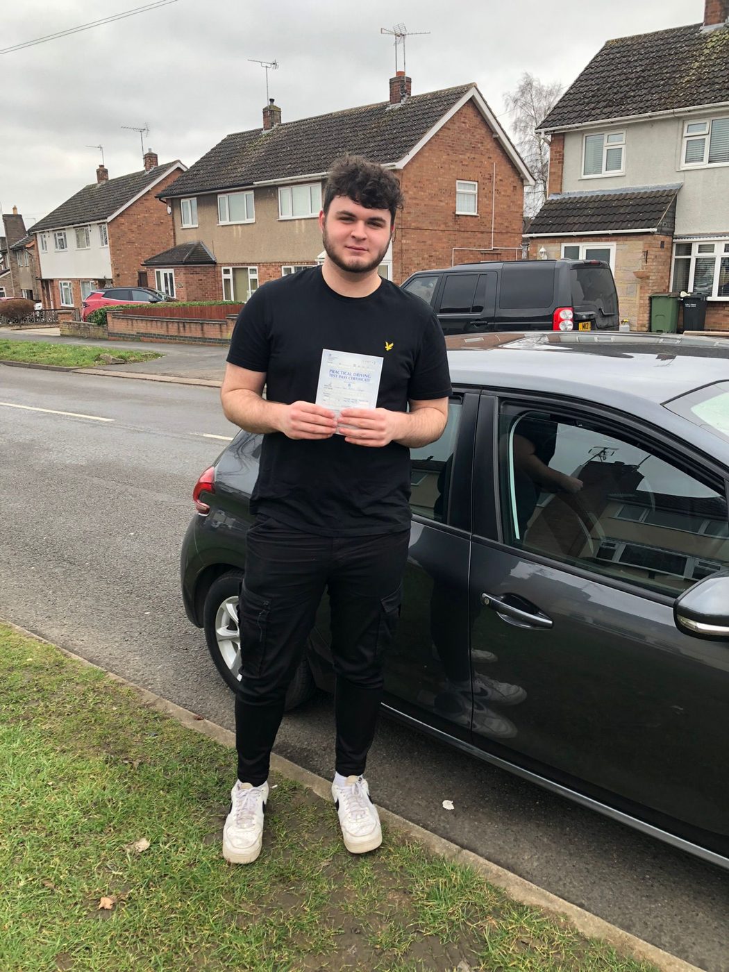 Learner with his pass certificate outside a Leicester home after passing his test