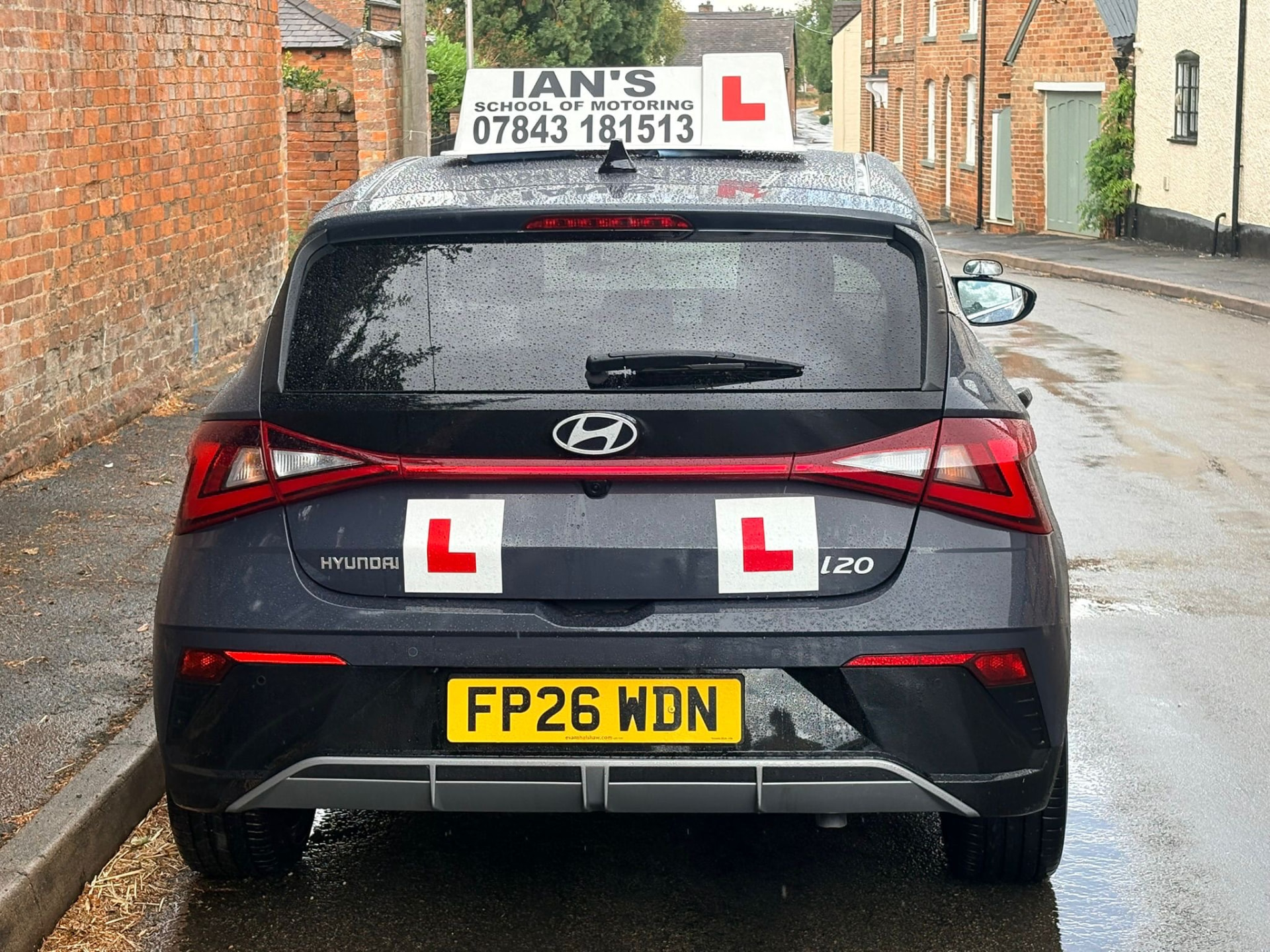 Rear of Ian's School of Motoring tuition car showing L plates and the 07843 181513 roof sign