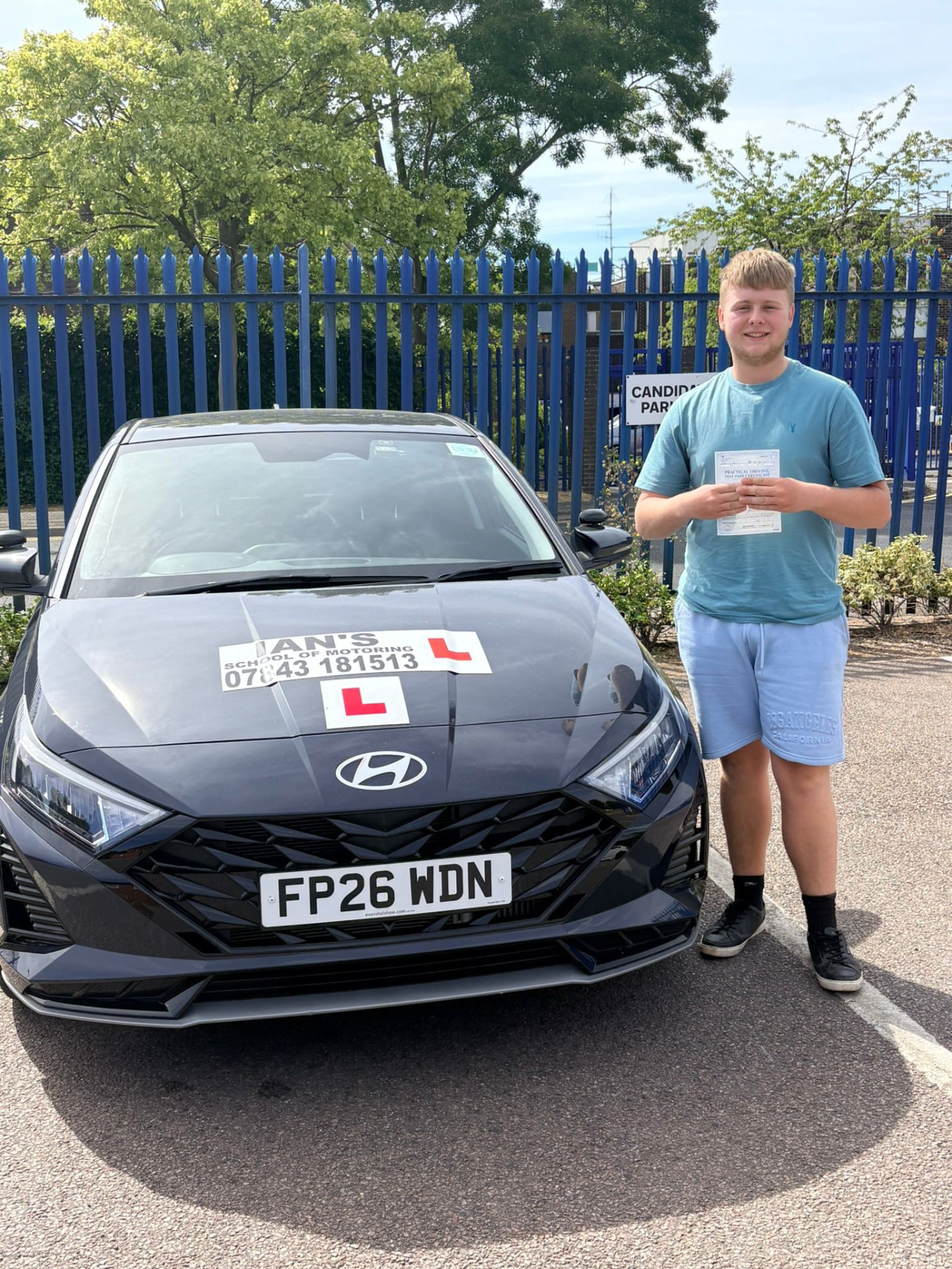 Learner with pass certificate next to Ian's School of Motoring Hyundai i20